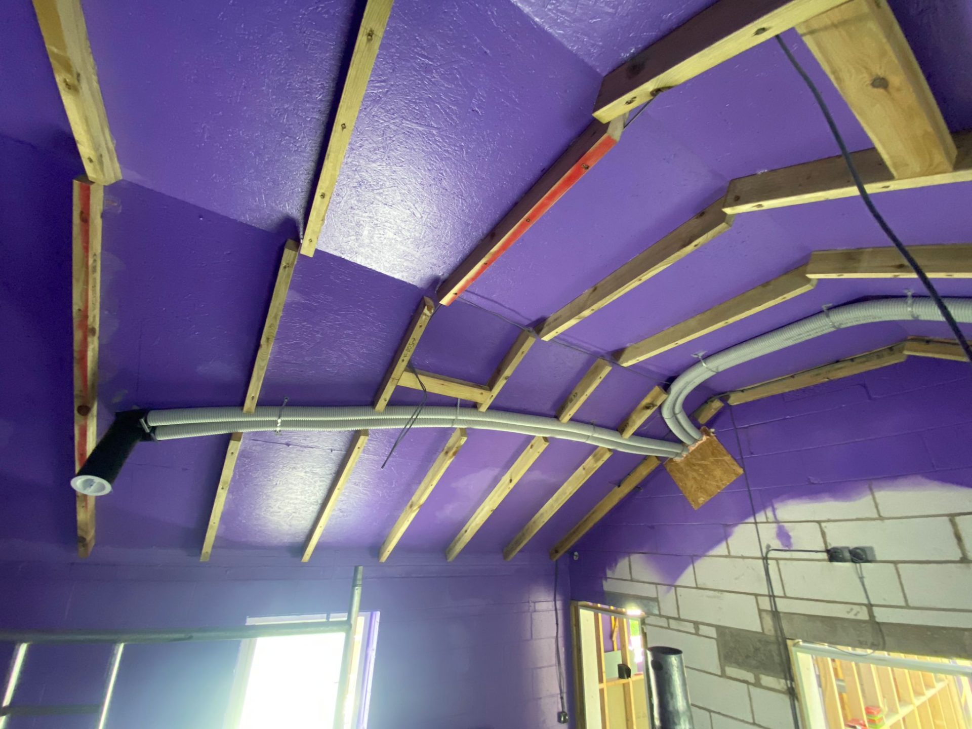 Close-up of airtight tape being applied to a timber frame junction for Passivhaus-level airtightness, showing precision workmanship and high-quality materials