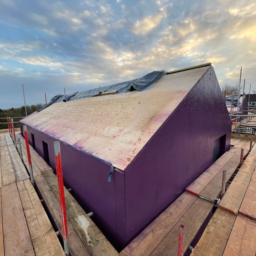 Coating external walls with Passive Purple External membrane to improve airtightness, water resistance, and vapour permeability